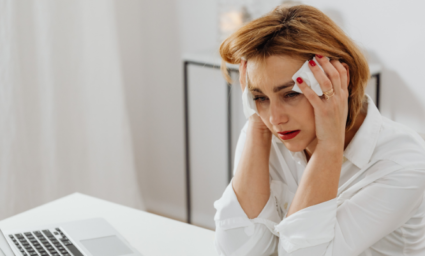 žena u počítače potýkající se s bolestí hlavy.