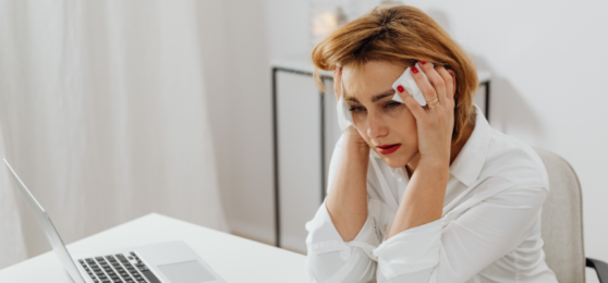 žena u počítače potýkající se s bolestí hlavy.