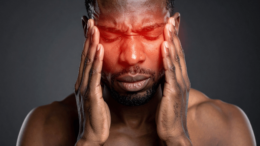 Muž pociťující silnou bolest hlavy.