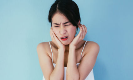 žena pociťující silnou bolest ucha.