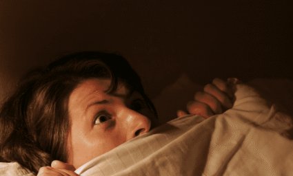 Vyděšená žen a v posteli.