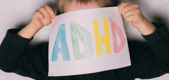 Dítě držící papír s nápisem ADHD.