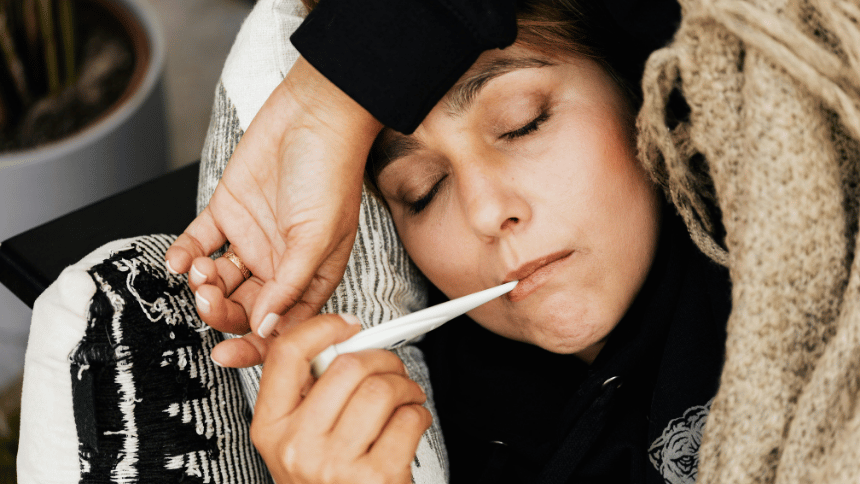 nemocná žena v posteli s teploměrem.