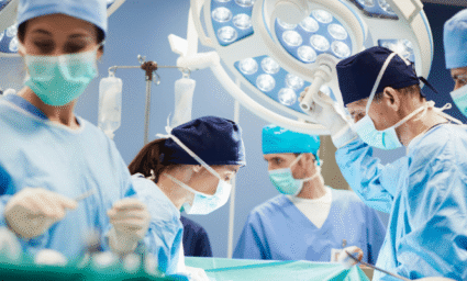 Doktoři sklánějící se nad operačním stolem.