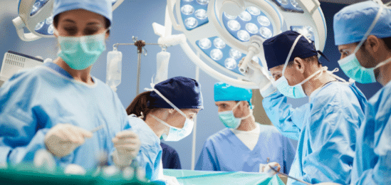Doktoři sklánějící se nad operačním stolem.
