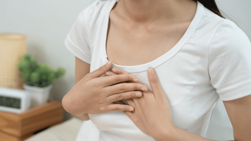 žena držící se na prsou, protože jí pálí žáha.