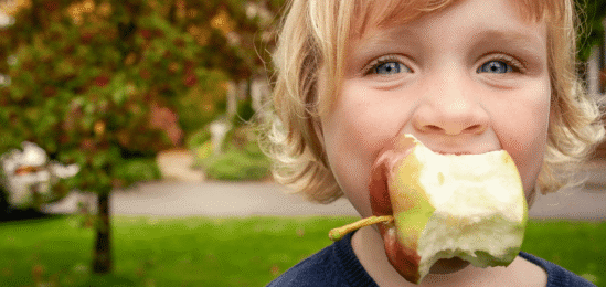 Dítě pojídající jablko.