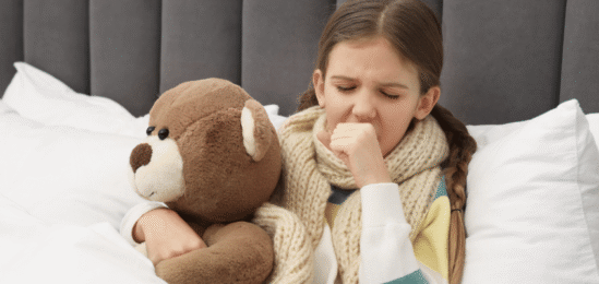 nemocná holčička v posteli s kašlem.