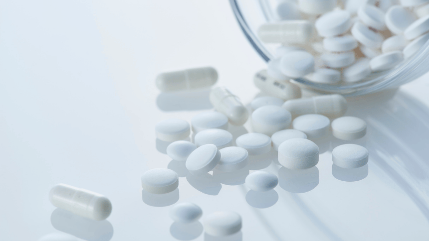 léky vysypané ze skleničky.