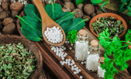 Dřevěná lžíce plná homeopatických tobolek.