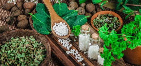 Dřevěná lžíce plná homeopatických tobolek.