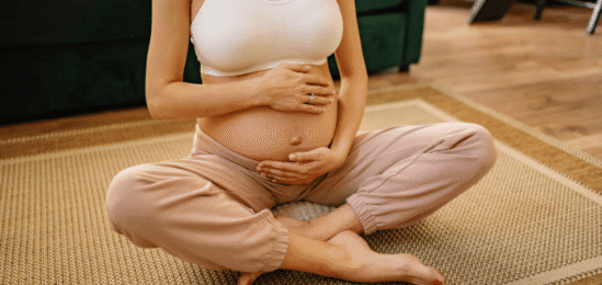 Těhotná žena s obnaženým břichem.